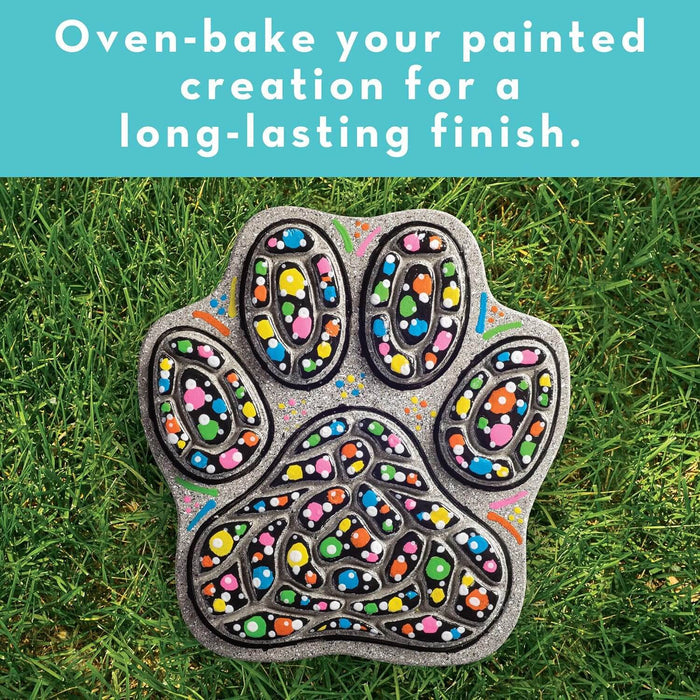 Glittery silver paw print stepping stone on green grass with colorful painted dots and text about oven-baking.