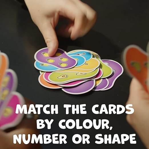 A hand touching colorful pear-shaped cards. Text: MATCH THE CARDS BY COLOUR, NUMBER OR SHAPE.