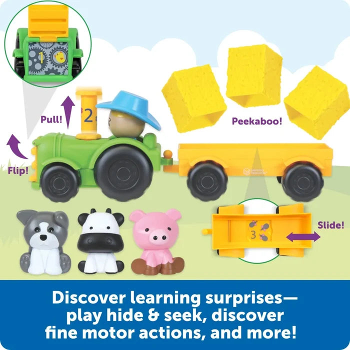 Green toy tractor and trailer with dog, cow, and pig figures, featuring interactive flip, pull, and slide play features.