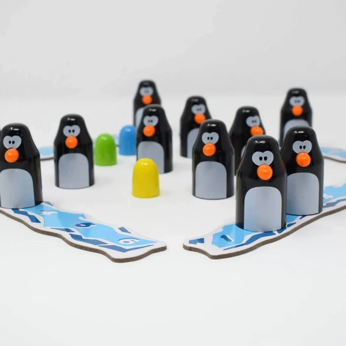 Wooden penguin game pieces with orange beaks on blue ice tracks with colorful eggs on a white background.