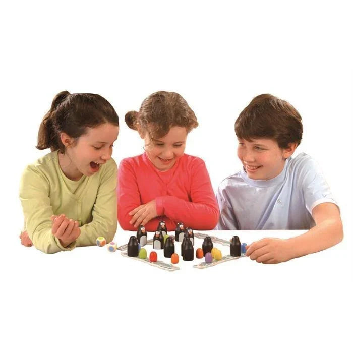 Three children playing a memory game with black penguin figures and colorful wooden eggs on a white background.