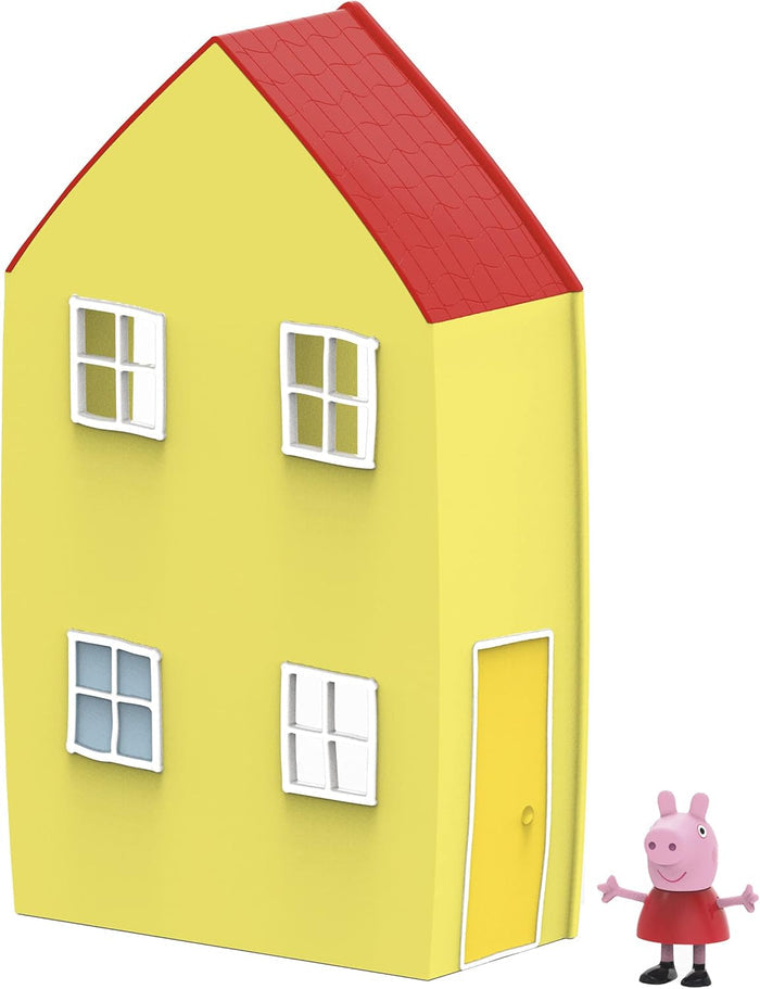 Yellow two-story toy house with a red roof and four windows, with a small Peppa Pig figure standing beside it.