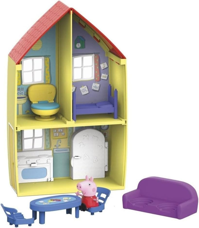 Two-story yellow toy house with red roof, furnished rooms, Peppa Pig figure, blue dining set, and purple sofa.
