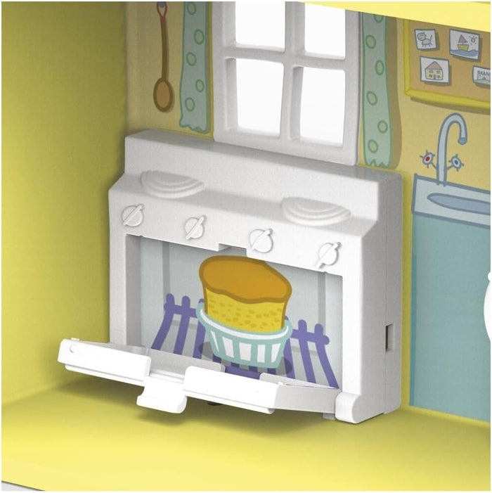 White toy stove with open oven door showing a cake inside, against a yellow wall with cartoon kitchen graphics.