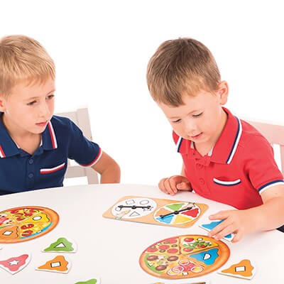 Two boys in red and blue shirts match colorful triangular pizza slices and shapes using a double spinner.