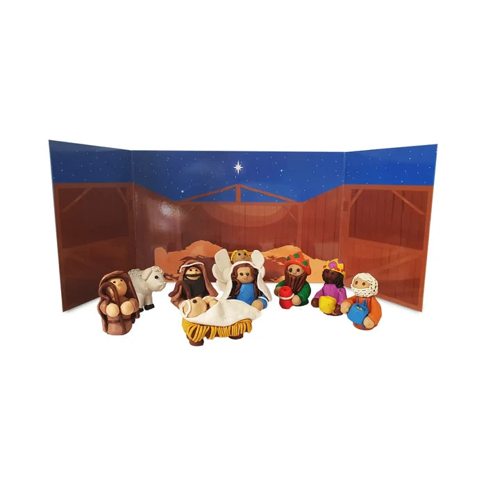 Handmade plasticine nativity scene with Mary, Joseph, and Jesus in a manger against a starry night stable backdrop.