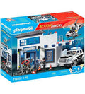 Blue toy box showing a white two-story police station with a helicopter, patrol SUV, and play figures.