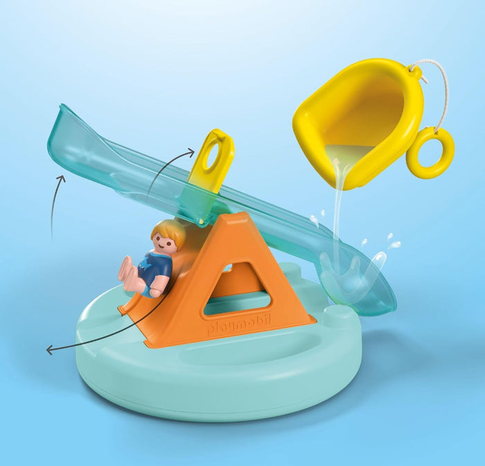 Water toy featuring a transparent blue seesaw, orange base, small figure, and a yellow scoop pouring water.