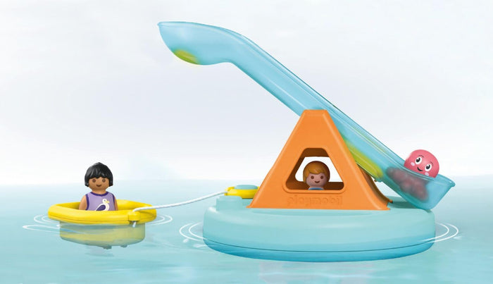 Floating light blue base with orange triangle slide, pink octopus, and figure in a yellow raft on water.