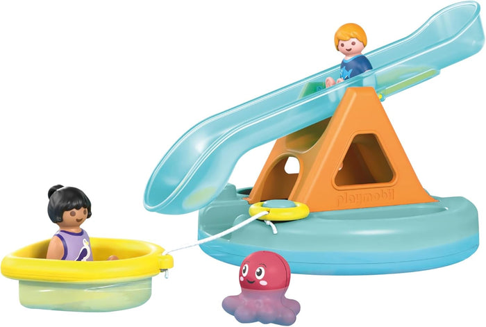 Blue slide on orange base with two child figures, a yellow boat, and a pink octopus toy on a teal floating platform.