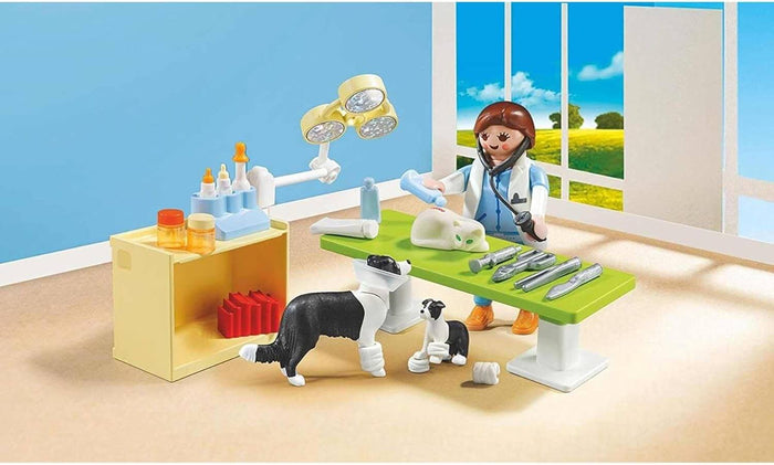 Playmobil vet figure treats a cat on a green table with two dogs and medical tools in a bright office scene.