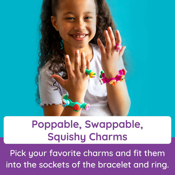 Smiling girl wearing colorful silicone bracelets and rings with swappable squishy animal and food charms.