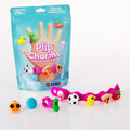 Teal toy pouch with a pink bracelet and ring plus squishy charms including a soccer ball, yellow duck, and pizza slice.