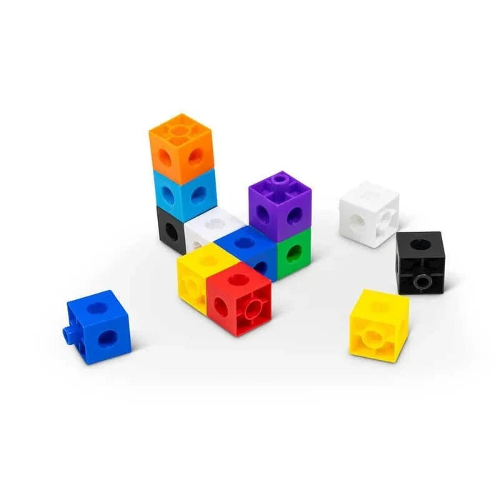 Colorful interlocking plastic cubes connected in various shapes and scattered on a white surface.