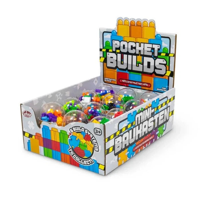 Display box of clear plastic capsules filled with tiny, colorful interlocking building blocks.