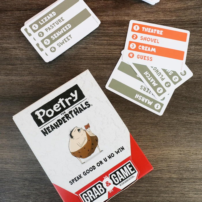 Poetry for Neanderthals card game box with caveman art and word cards on a dark wood surface.