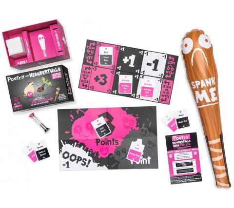 Pink and black card game components spread out next to a large inflatable brown club with SPANK ME written on it.