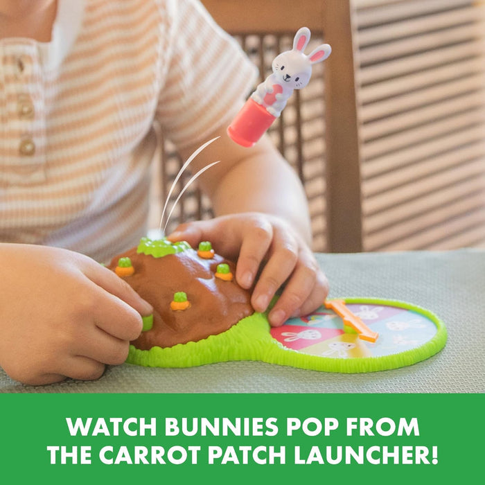 White bunny toy launching from a brown carrot patch mound next to a colorful spinner as a child plays.