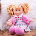 Blonde rag doll with yarn pigtails, pink cardigan, and floral dress with colorful buttons on white faux fur.