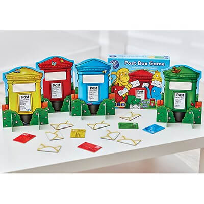 Four colorful toy post boxes in red, yellow, blue, and green with matching envelopes and the game box.