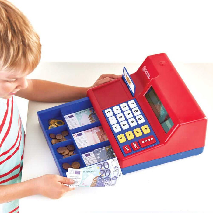 Red toy cash register with blue accents, a solar keypad, and an open drawer filled with play Euro coins and bills.
