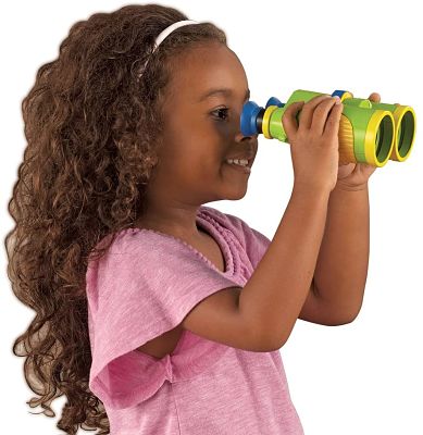 Young girl with long curly hair looking through green and yellow toy binoculars with blue eyepieces.