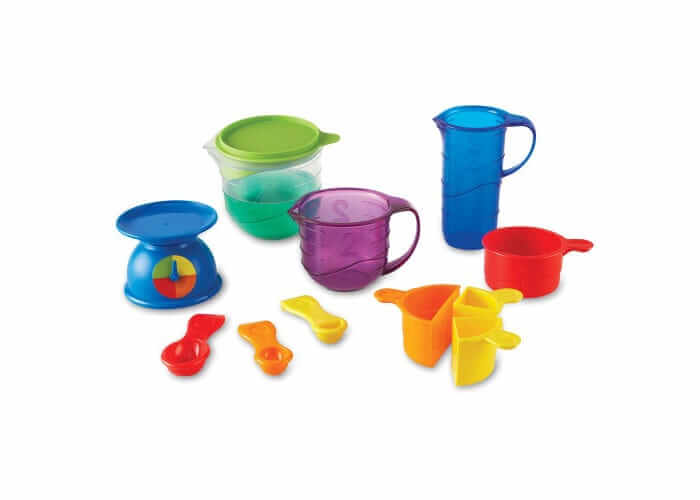 Colorful plastic measuring tools including a blue scale, pitchers, and various cups and spoons in bright colors.