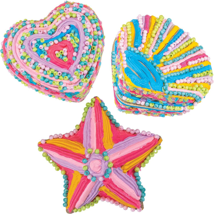 Heart, shell, and star shapes decorated with thick, vibrant lines of puffy paint and small colorful beads.