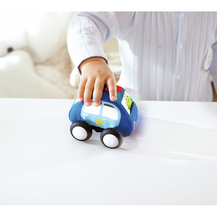 Toddler's hand pushing a soft blue plush car with white wheels and a yellow star on its side.