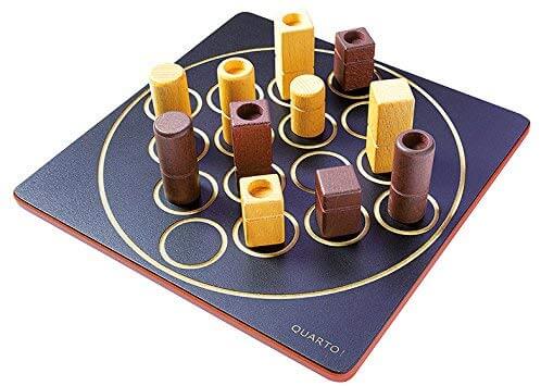 Square black game board with light and dark wooden pieces in various shapes and heights on gold circular outlines.