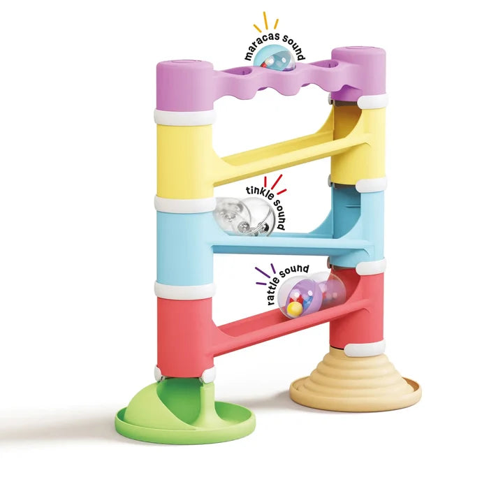 Colorful 4-tier toy marble run with pastel tracks and three clear spheres containing small multicolored beads.