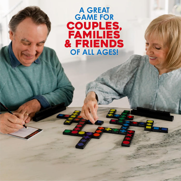 An older couple playing a game with black tiles featuring colorful shapes like stars and circles on a marble table.