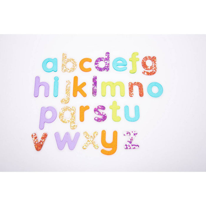 Lowercase letters a-z in four rows, featuring a mix of solid colors and sparkly glitter patterns on white.