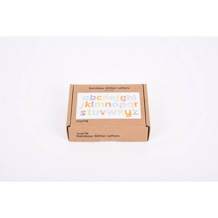 Small brown cardboard box with a label showing sparkly, rainbow-colored lowercase alphabet letters from a to z.