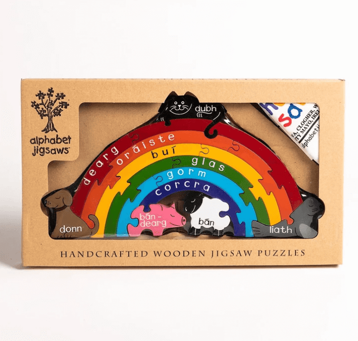Handcrafted wooden arch puzzle in a box with colorful layers, Irish text, and pieces shaped like a cat, dog, and pig.
