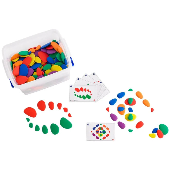 Colorful smooth pebbles in a clear storage bin with activity cards and stone patterns arranged on a white surface.
