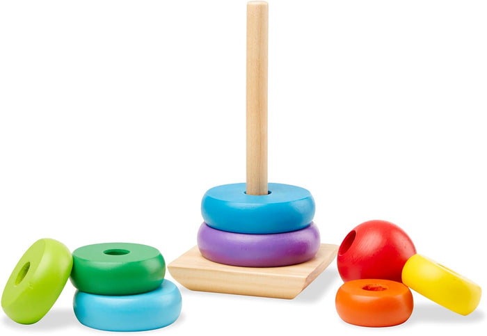 Wooden stacking toy with colorful rings and a red topper scattered around a central peg and square base.