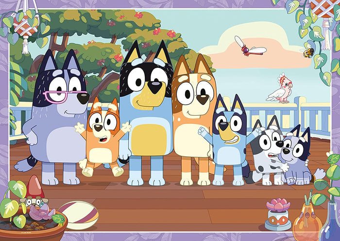 Bluey, Bingo, and family stand on a sunlit wooden deck with a pink cockatoo and lush greenery in the background.