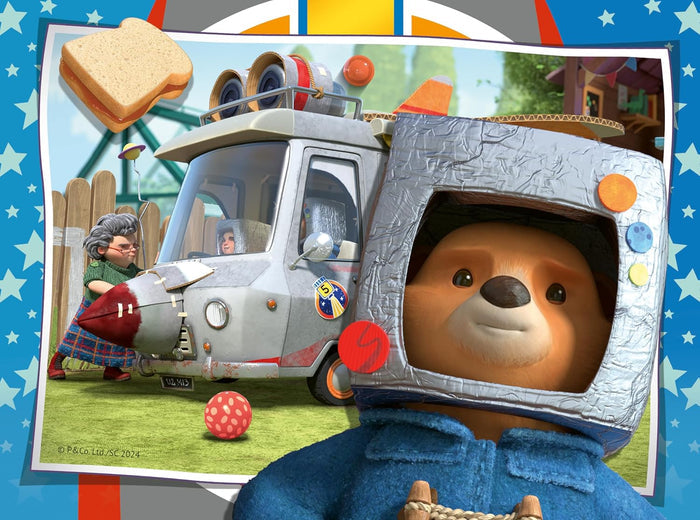 Paddington Bear wearing a silver cardboard space helmet next to a rocket-themed camper van and a floating sandwich.