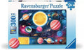 Ravensburger puzzle box with a vibrant space scene of colorful planets and a glowing sun against a dark starry sky.