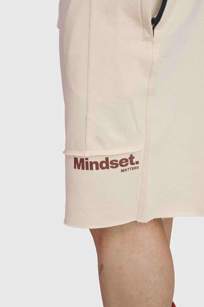 Beige raw edge oversized shorts by Fuaark Nz, featuring a relaxed fit and casual style, shown on a model.