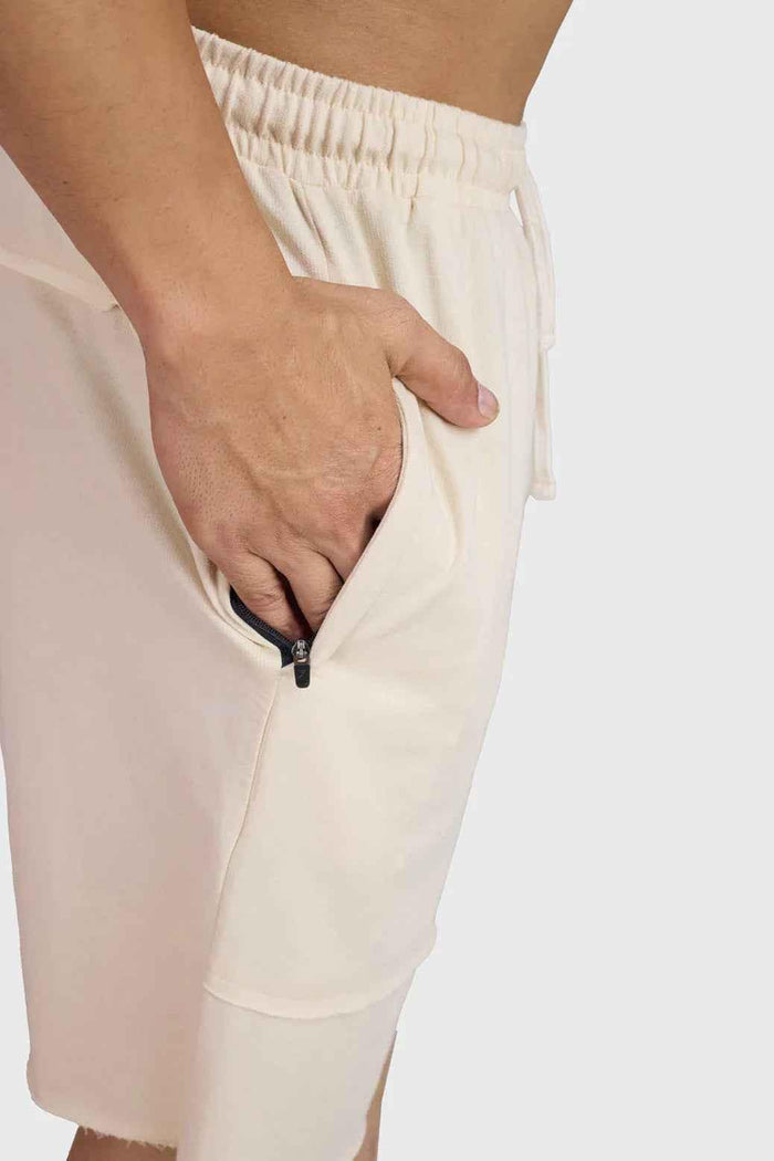 Beige raw edge oversized shorts by Fuaark Nz, casual fit with frayed hem, lightweight fabric, and relaxed style.