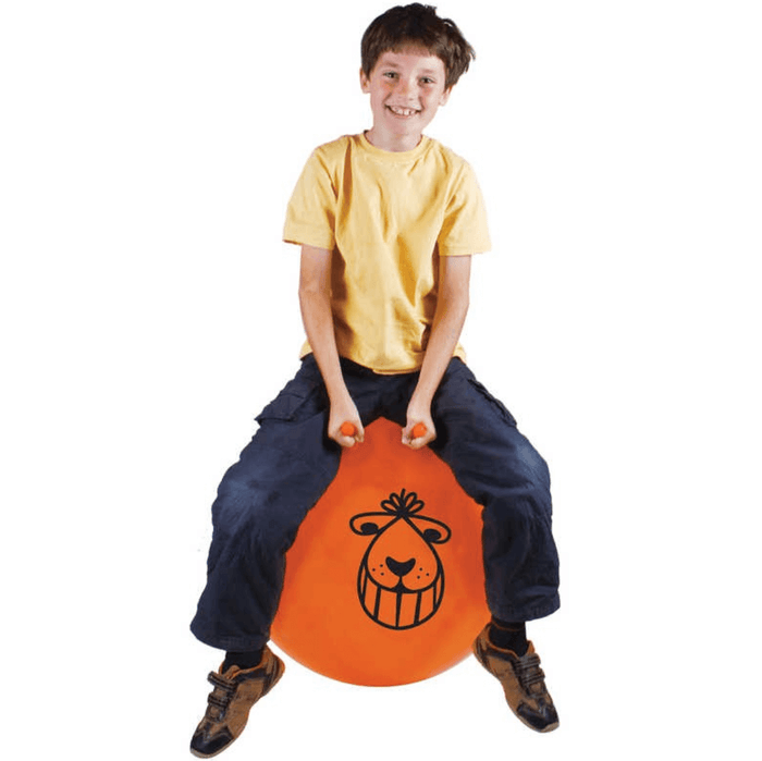 Smiling boy on an orange inflatable space hopper with two handles and a black cartoon face print.