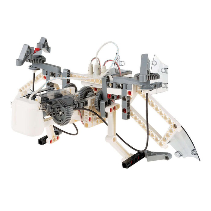 White and gray robotic model with visible gears, wires, and mechanical legs made from interlocking plastic beams.
