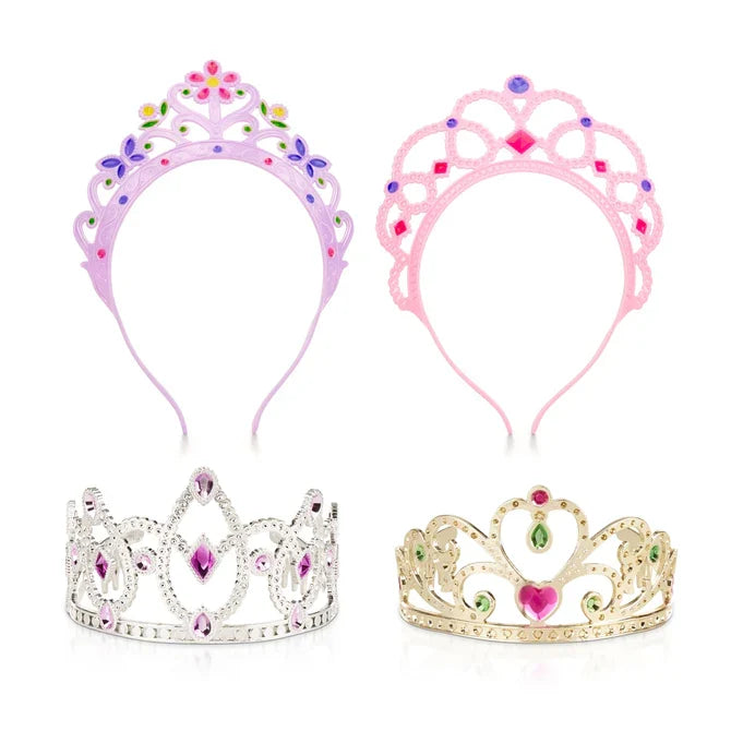 Four toy tiaras: purple and pink headbands with floral details, and silver and gold crowns with colorful plastic gems.