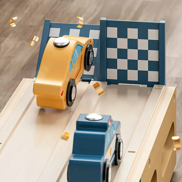 Yellow and blue wooden cars racing on a wood ramp through a checkered finish line gate with gold confetti.