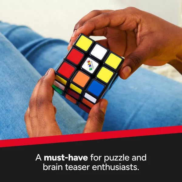 Hands holding a scrambled 3x3 Rubik's cube with bright colored stickers and a white center logo.