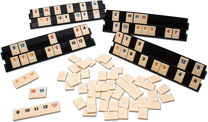 Four black racks with numbered game tiles in red, blue, black, and orange, with extra tiles scattered on a white surface.