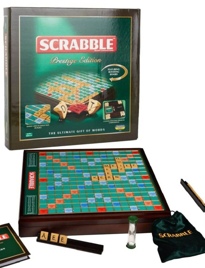 Scrabble Prestige box and game set with wooden board, letter tiles on racks, green velvet bag, and a sand timer.