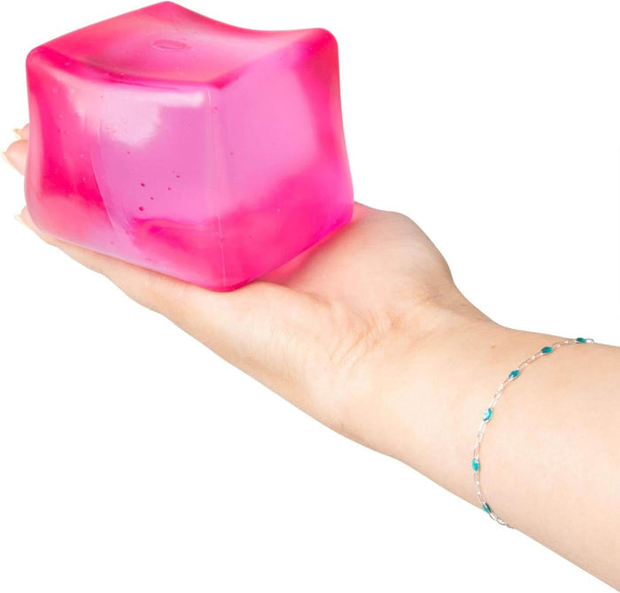 Giant translucent pink squishy cube toy held in a palm, showing its soft, jelly-like texture.